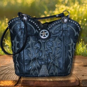 Black cowboy boot purse with horse tack handles, engraved spots and a star concho on front.