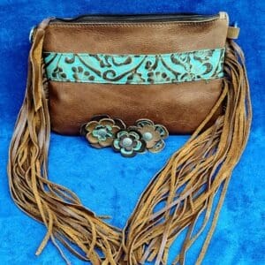 Brown oil tanned leather crossbody purse with fringe and turquoise tooled leather. Add some fancy leather flowers with conchos.