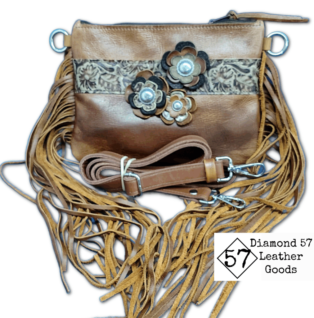 Brown leather crossbody bag with fringe and flowers. Leather strap is adjustable.