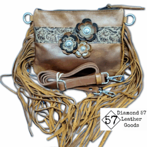 Brown leather crossbody bag with fringe and flowers. Leather strap is adjustable.